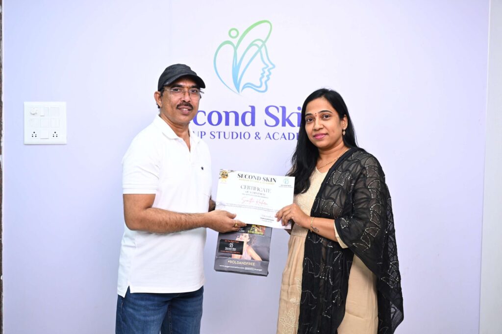 Student receiving a makeup course completion certificate from Chakravarthi Kadali at Second Skin Makeup Academy, Hyderabad