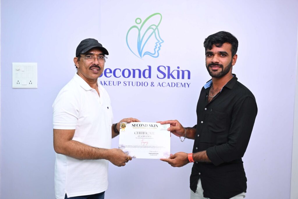 Student receiving a makeup course completion certificate from Chakravarthi Kadali at Second Skin Makeup Academy, Hyderabad