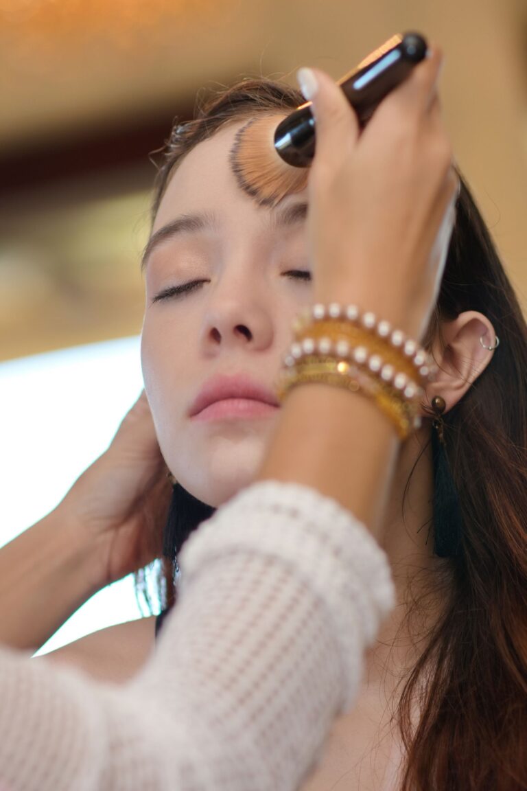 Makeup artist applying a long-wear base with a brush during setting and finishing training in Hyderabad