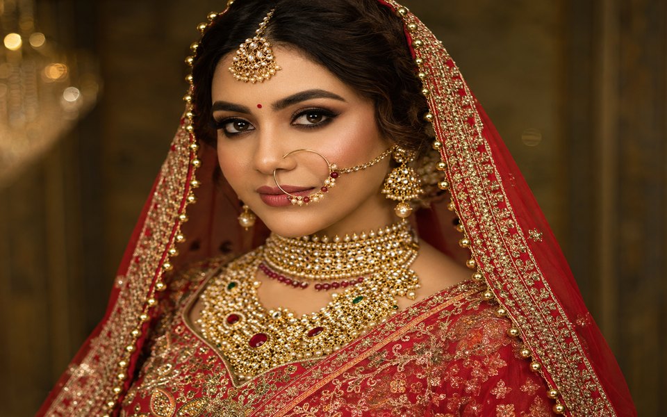 Indian bride in red lehenga with gold kundan jewellery and a traditional bridal makeup look