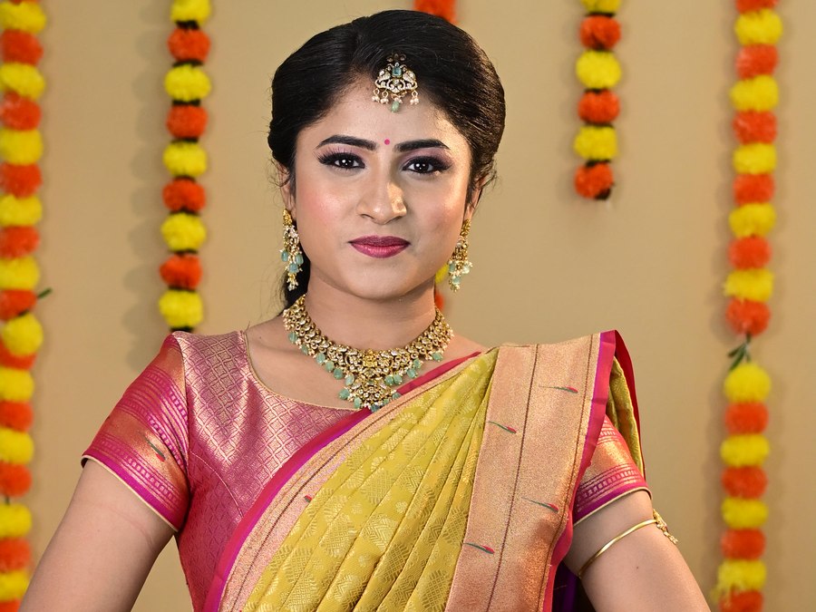 Woman in a Kanjivaram saree draped in a traditional South Indian style with temple jewellery