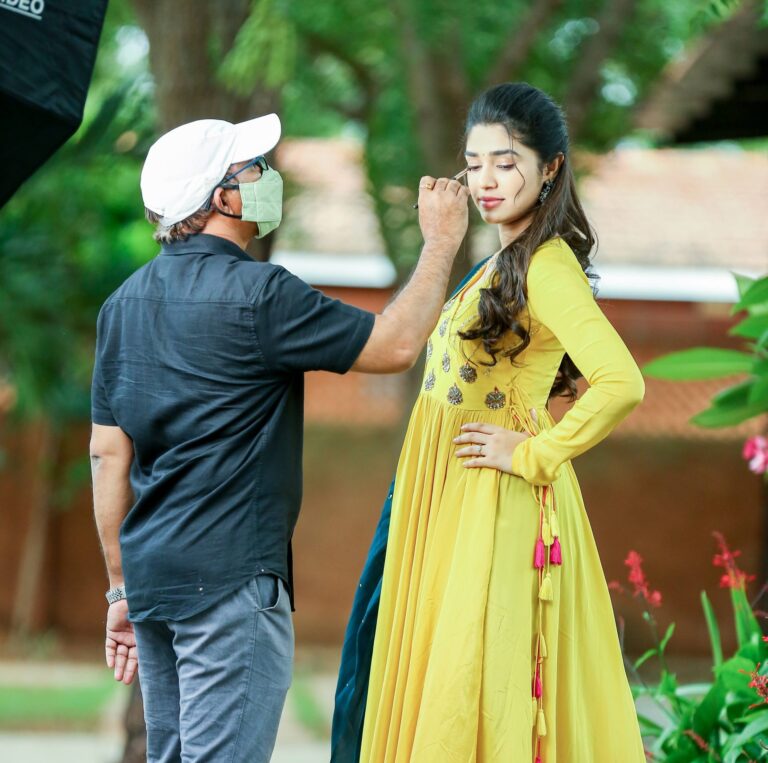 Chakravarthi Kadali applying makeup to an actress on a Tollywood film set, the working experience behind the Hyderabad academy
